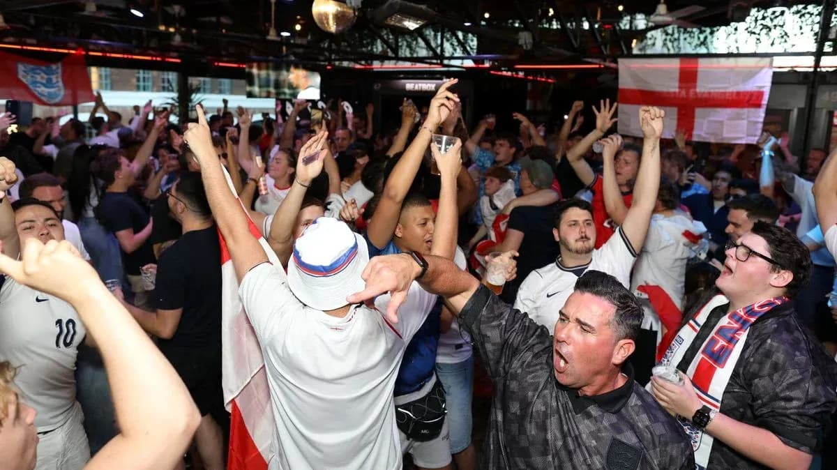 Aficionados celebrando en bar con banderas de Inglaterra