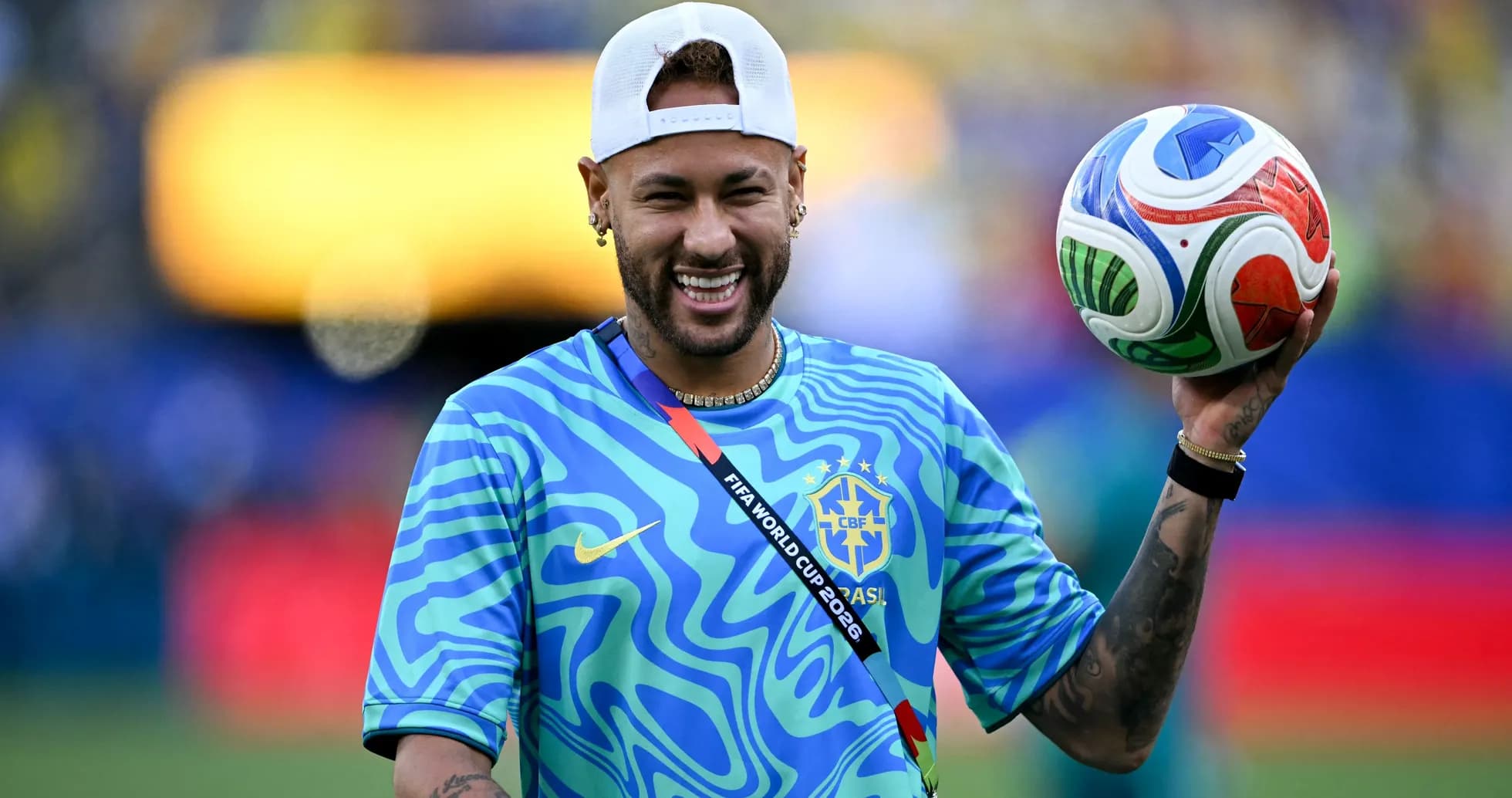 Neymar sosteniendo un balón en el campo de juego