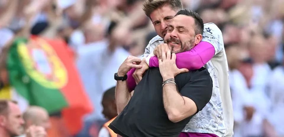 Entrenador y asistente celebrando en el campo