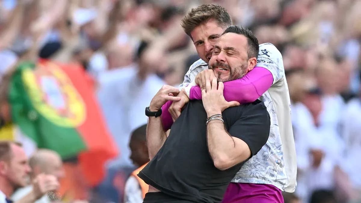 Entrenador y asistente celebrando en el campo