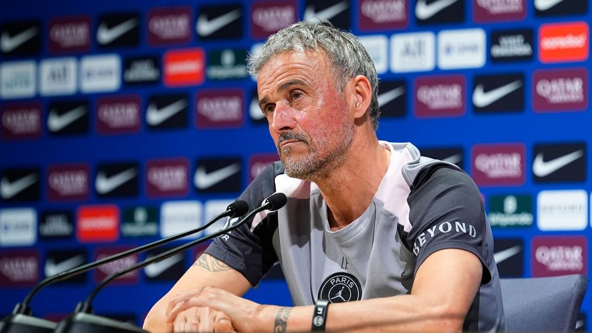 Entrenador en conferencia de prensa con fondo patrocinador