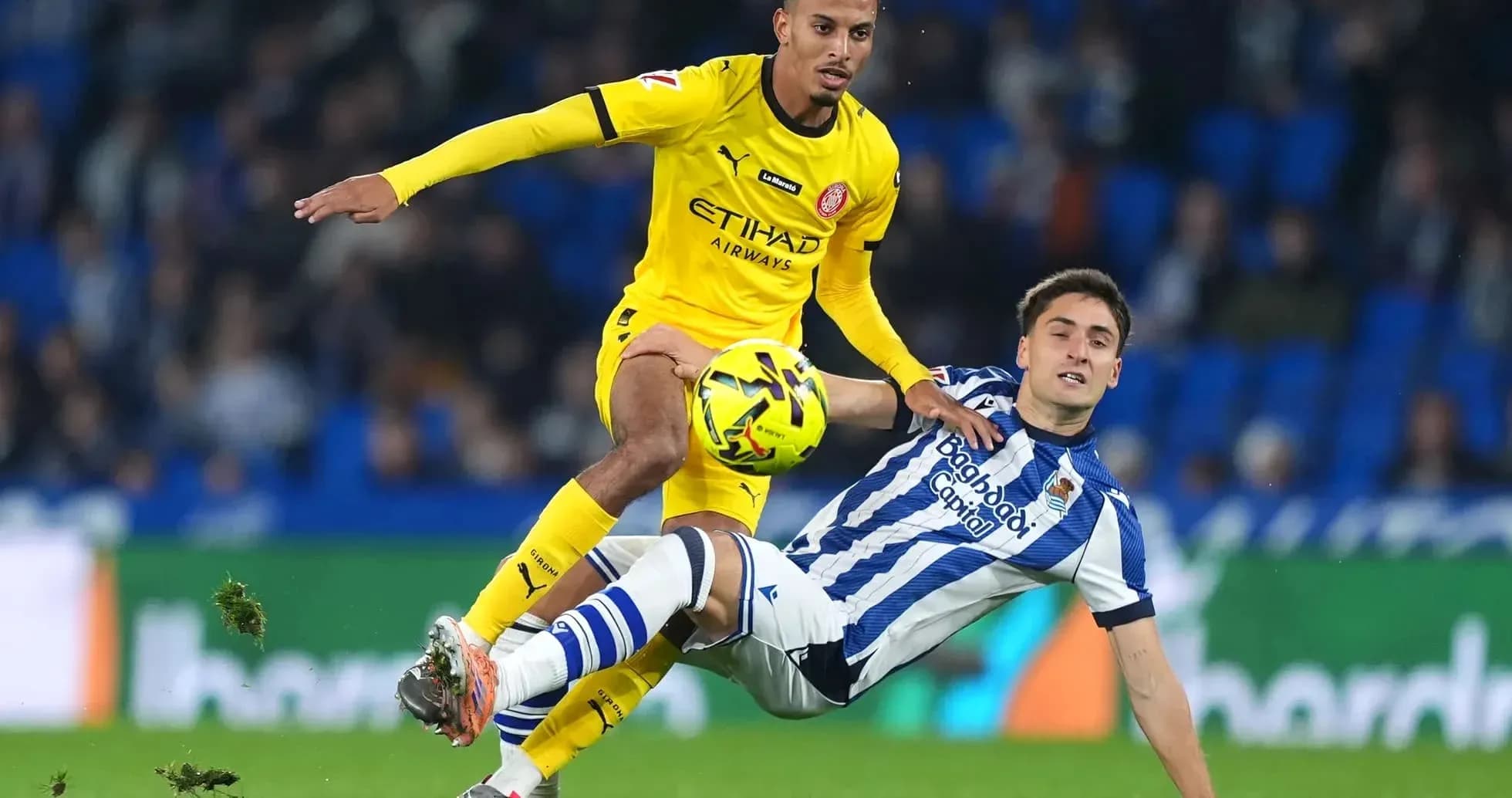 Jugador de Girona desafiando a rival de Real Sociedad