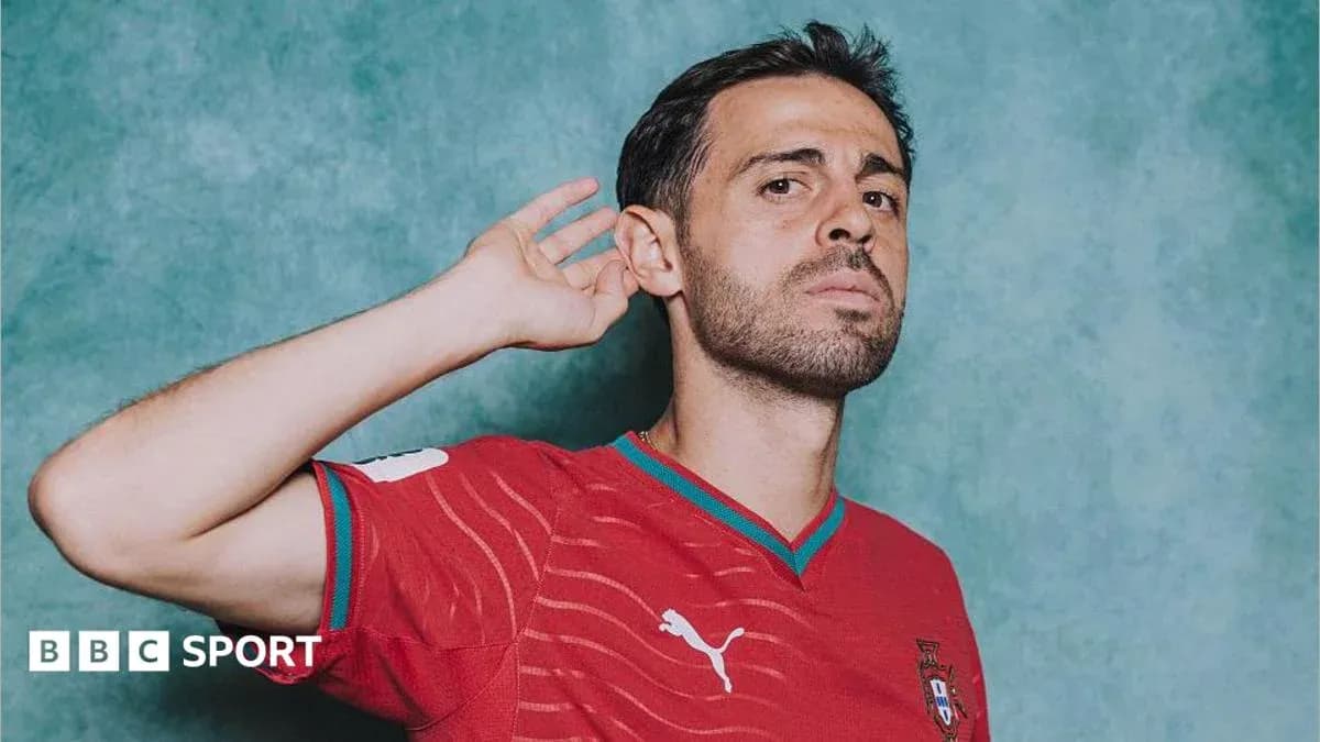 Jugador de fútbol con camiseta roja posando para la foto