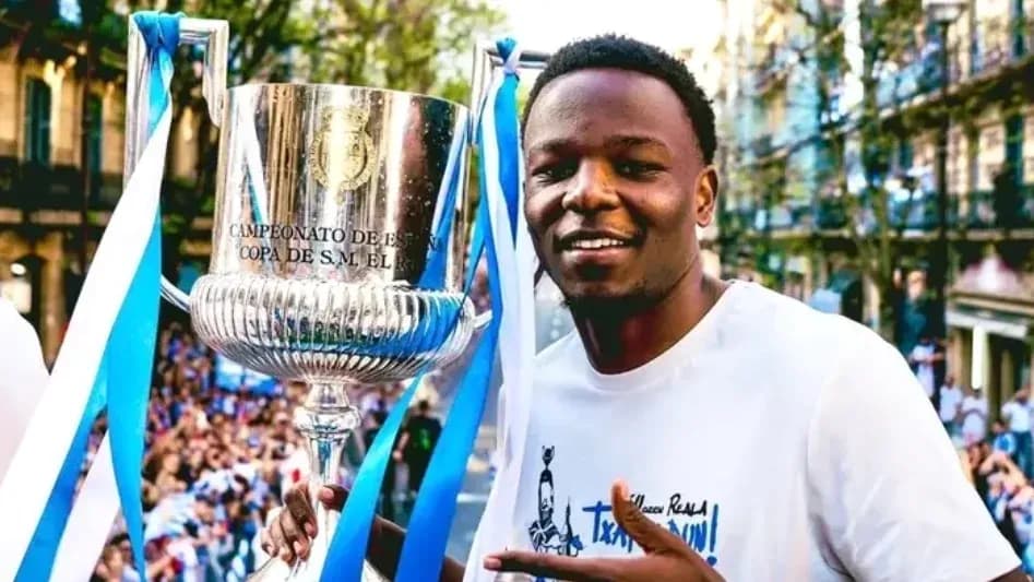 Jugador sosteniendo trofeo en celebración callejera