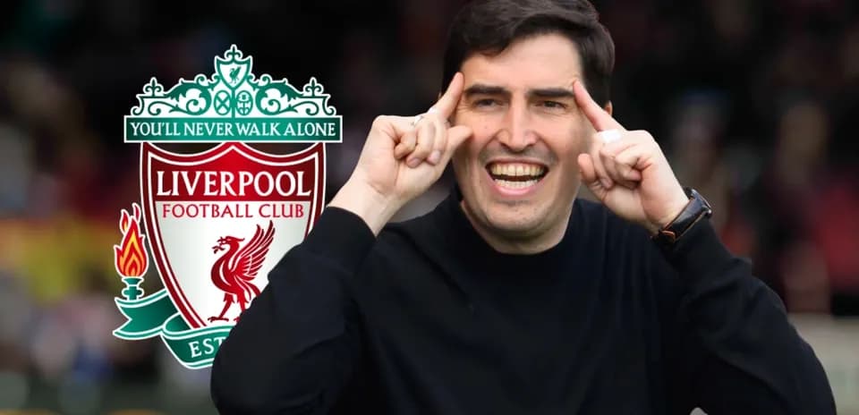 Entrenador señalando mientras sonríe con logo de Liverpool