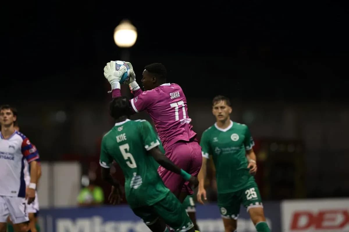 Portero atrapando el balón durante el partido