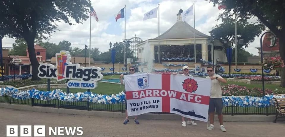 Dos aficionados sosteniendo una bandera de Barrow AFC en Six Flags