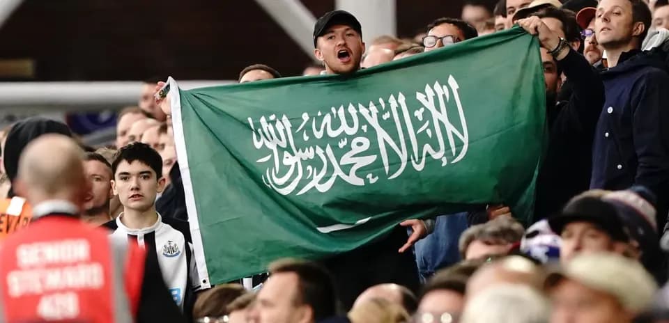 Aficionado sosteniendo una bandera de Arabia Saudita en el estadio