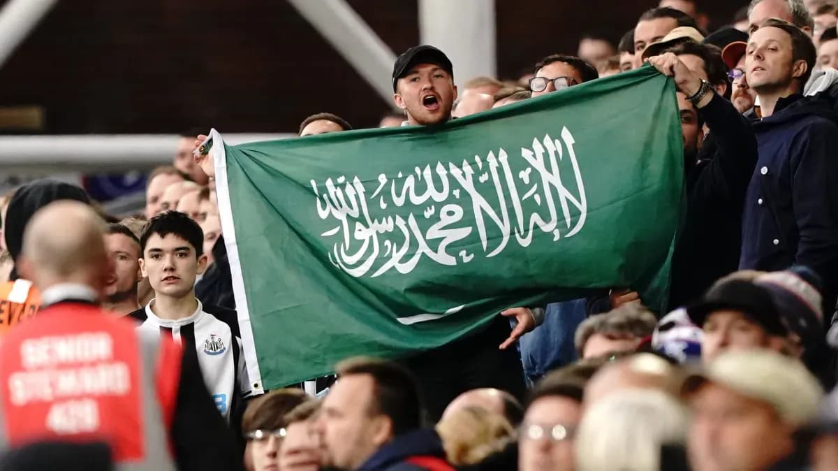 Aficionado sosteniendo una bandera de Arabia Saudita en el estadio