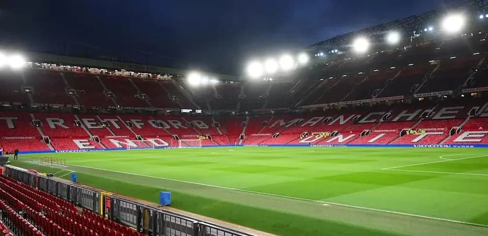 Estadio Old Trafford con césped y asientos vacíos