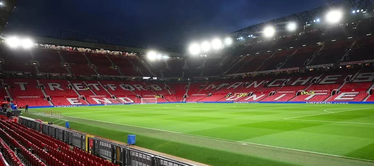 Estadio Old Trafford con césped y asientos vacíos