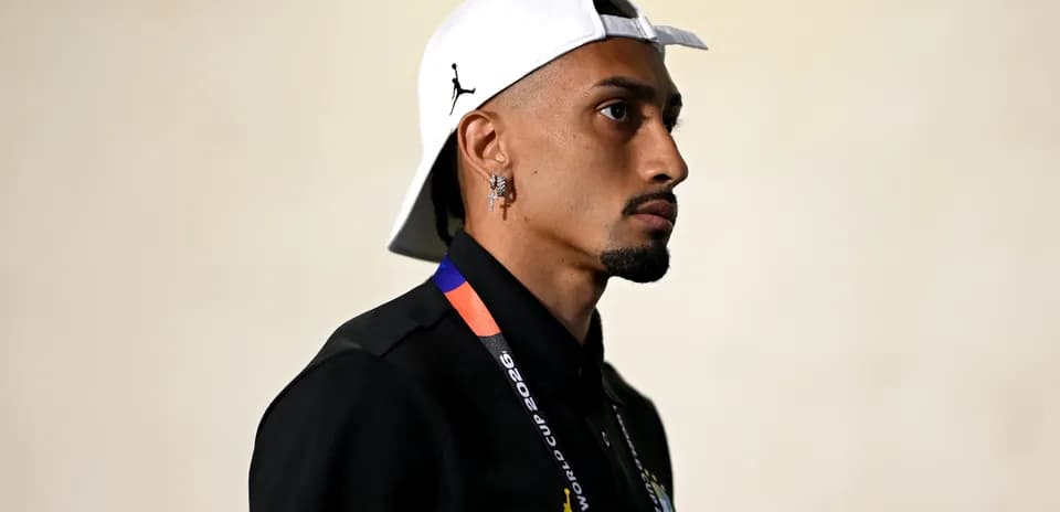 Jugador con gorra blanca y camiseta negra en pasillo