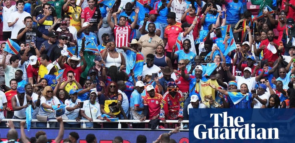 Aficionados animando con banderas en un estadio