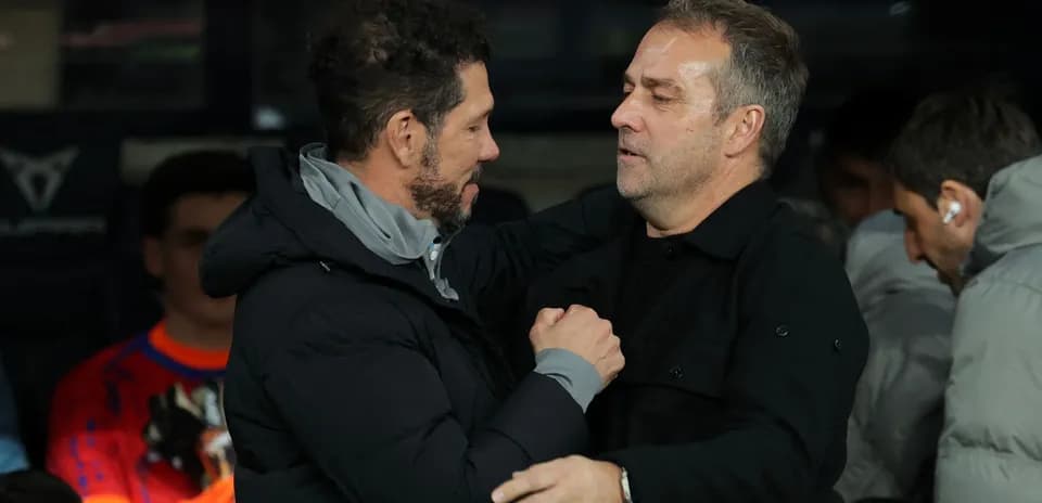 Entrenadores saludándose en la banca durante el partido