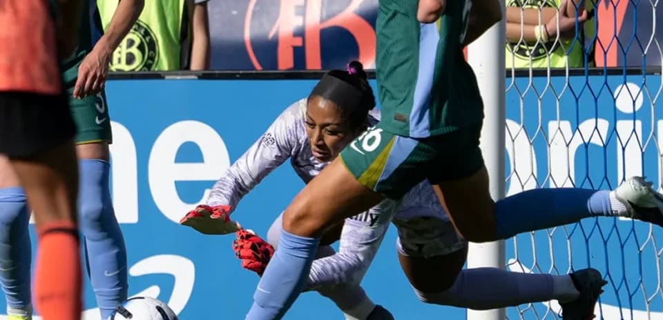 Portera atrapando el balón en el partido