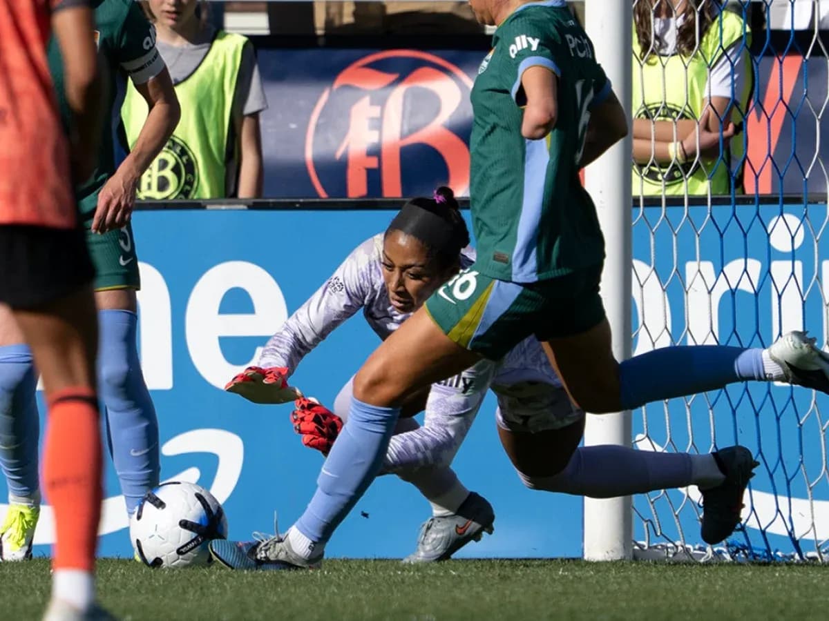 Portera atrapando el balón en el partido