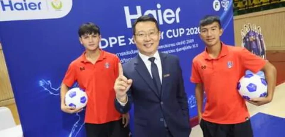 Tres personas posando con balón de fútbol en evento