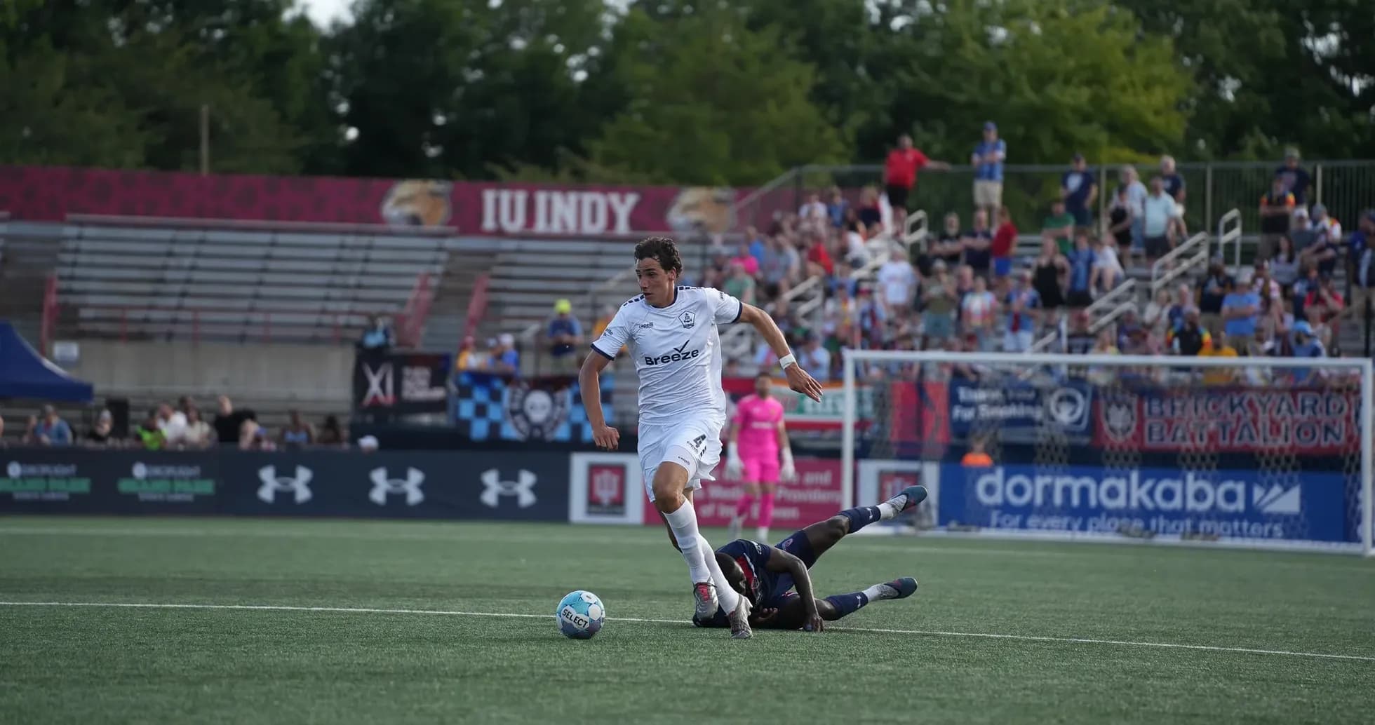 Jugador de Indy Eleven esquivando a oponente caído