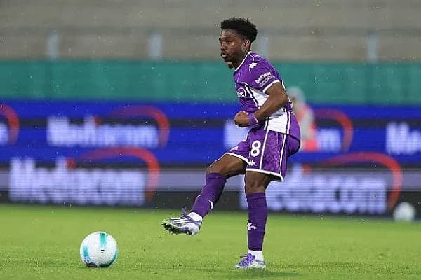 Jugador con balón en campo durante partido de fútbol