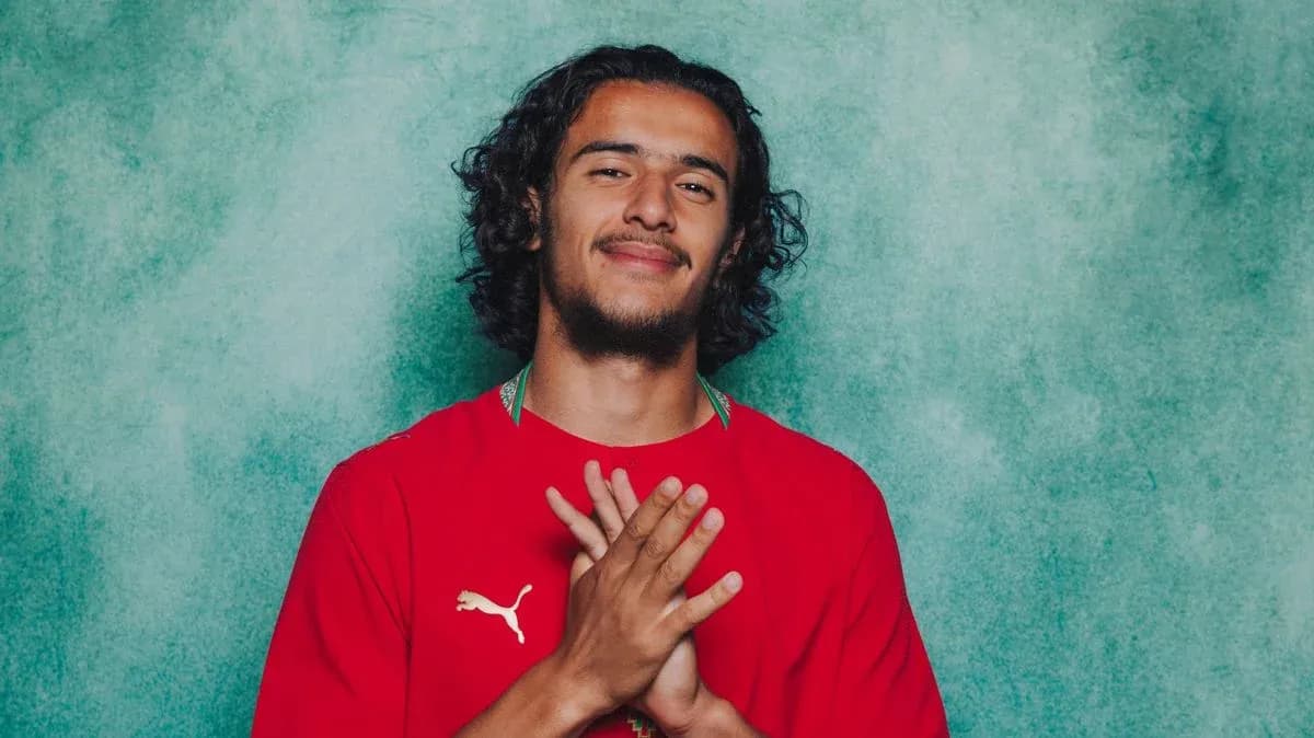 Jugador con camiseta roja posando frente a fondo verde