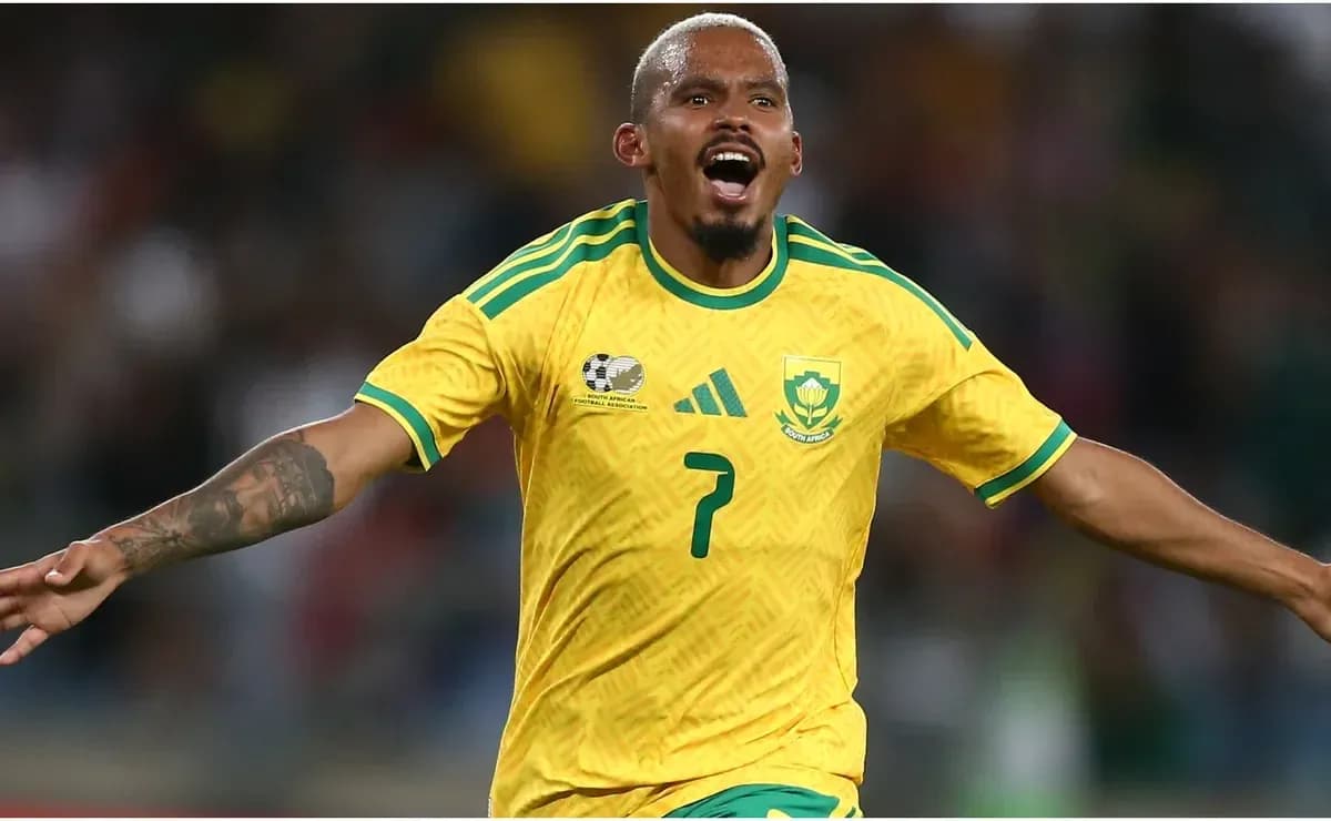 Jugador celebrando un gol con camiseta amarilla de Sudáfrica