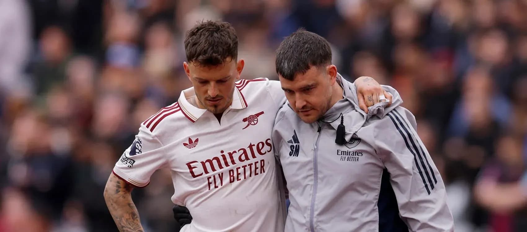 Jugador de Arsenal siendo ayudado por personal médico