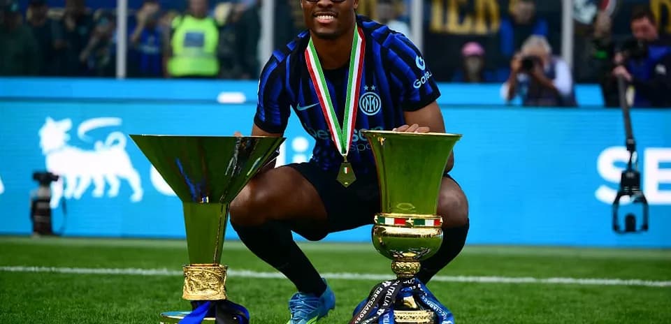Jugador de Inter celebrando con dos trofeos