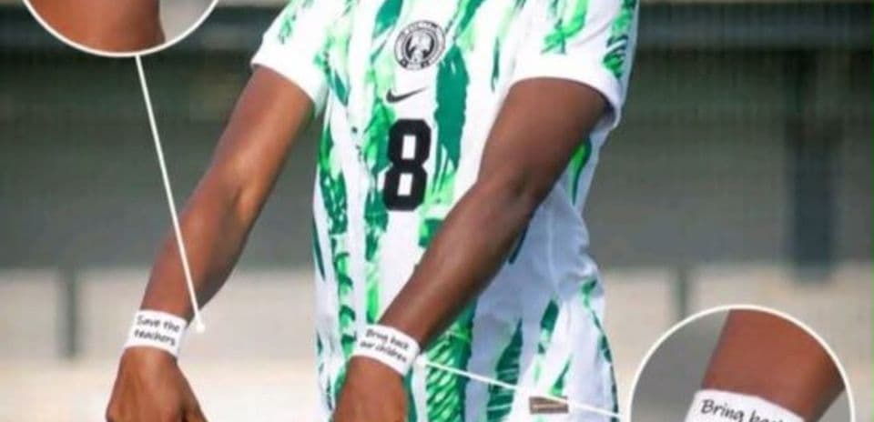 Jugadora con camiseta de Nigeria mostrando mensajes en las muñecas