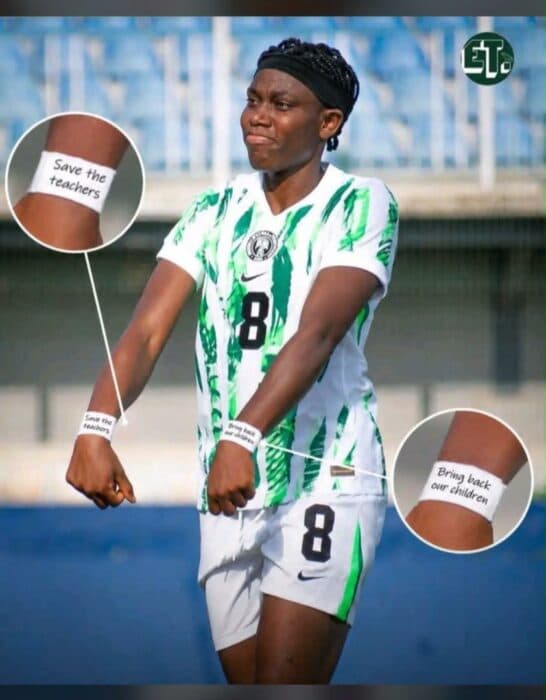 Jugadora con camiseta de Nigeria mostrando mensajes en las muñecas