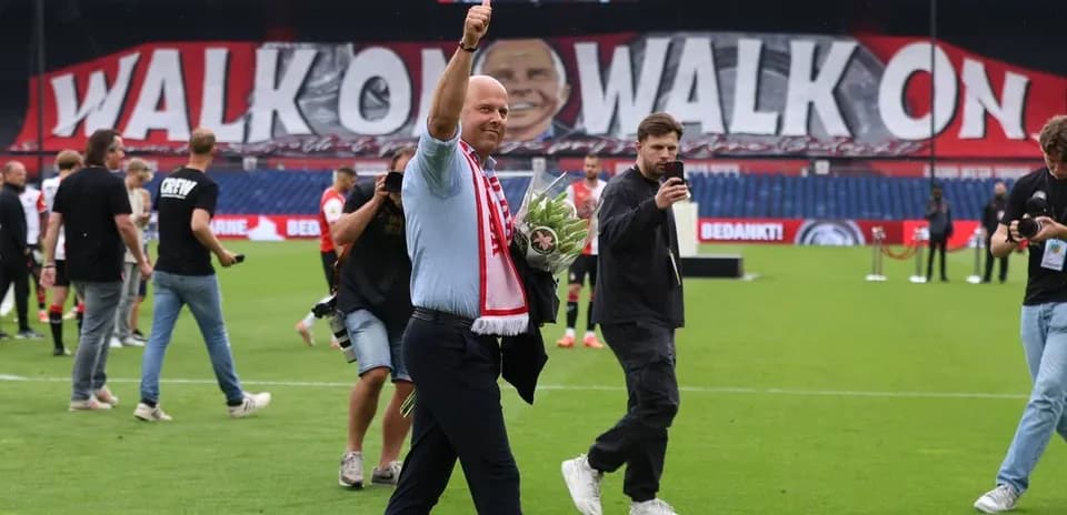Hombre saludando con flores en campo de fútbol