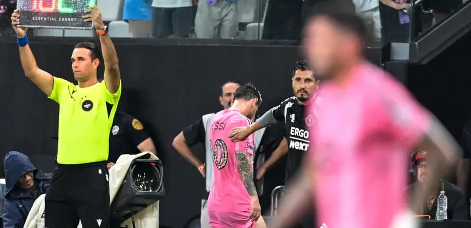 Jugadores y árbitro en sustitución durante el partido
