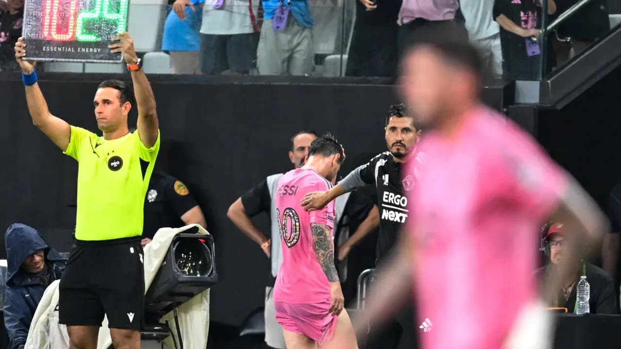 Jugadores y árbitro en sustitución durante el partido