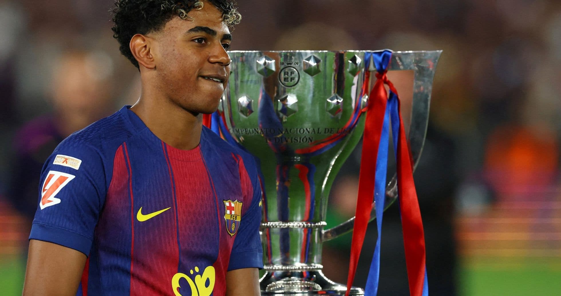 Jugador del FC Barcelona junto al trofeo de campeonato