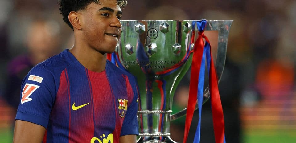Jugador del FC Barcelona junto al trofeo de campeonato