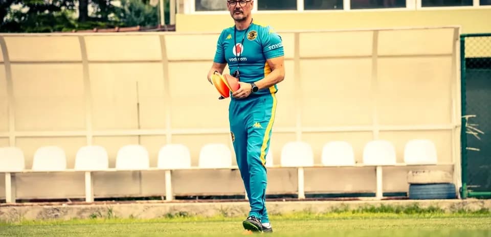 Entrenador caminando con conos en el campo