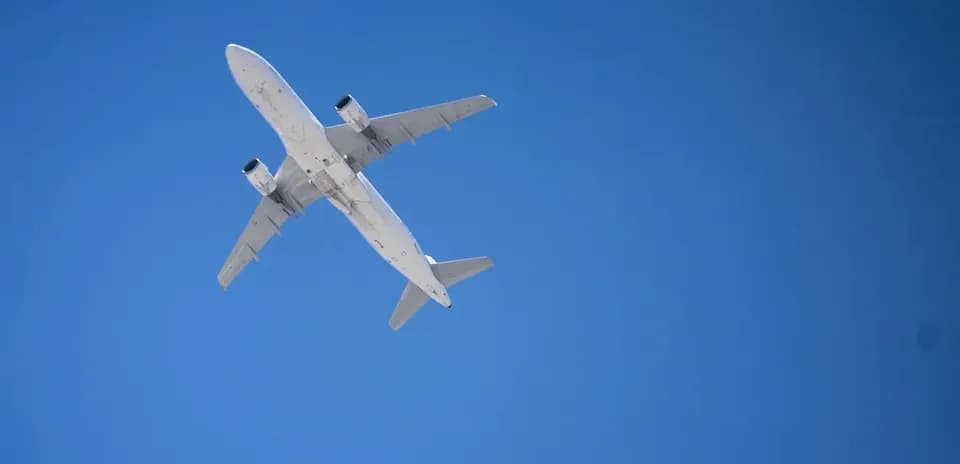 Avión volando alto en el cielo azul