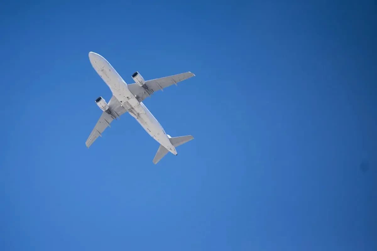 Avión volando alto en el cielo azul