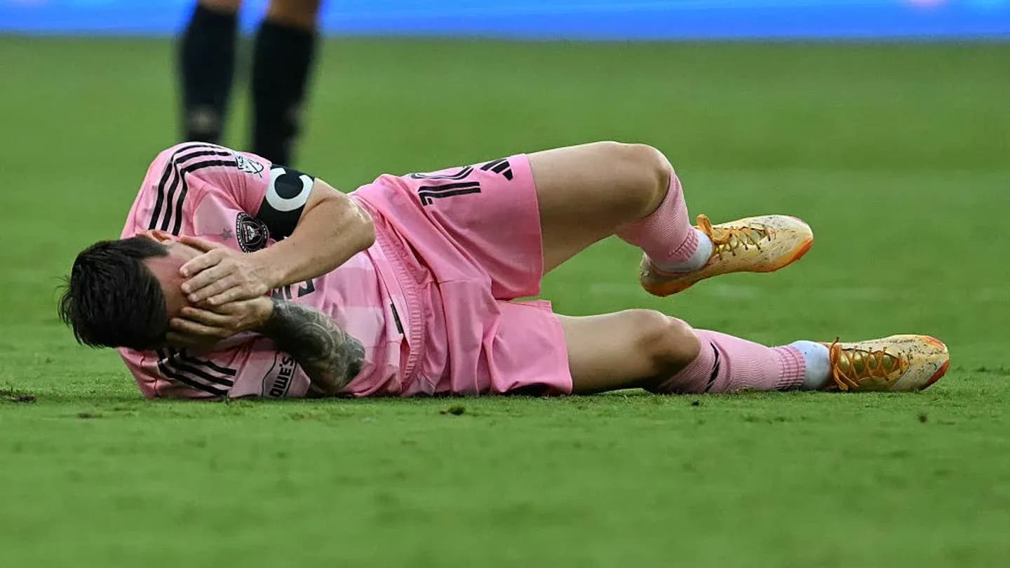Jugador caído en el campo con uniforme rosa