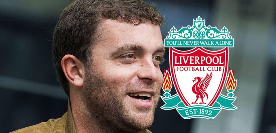 Hombre sonriendo junto al escudo de Liverpool FC