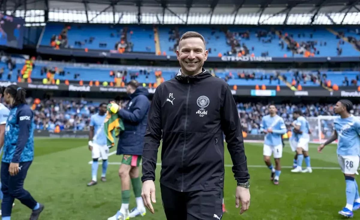 Entrenador sonriendo en el campo tras el partido