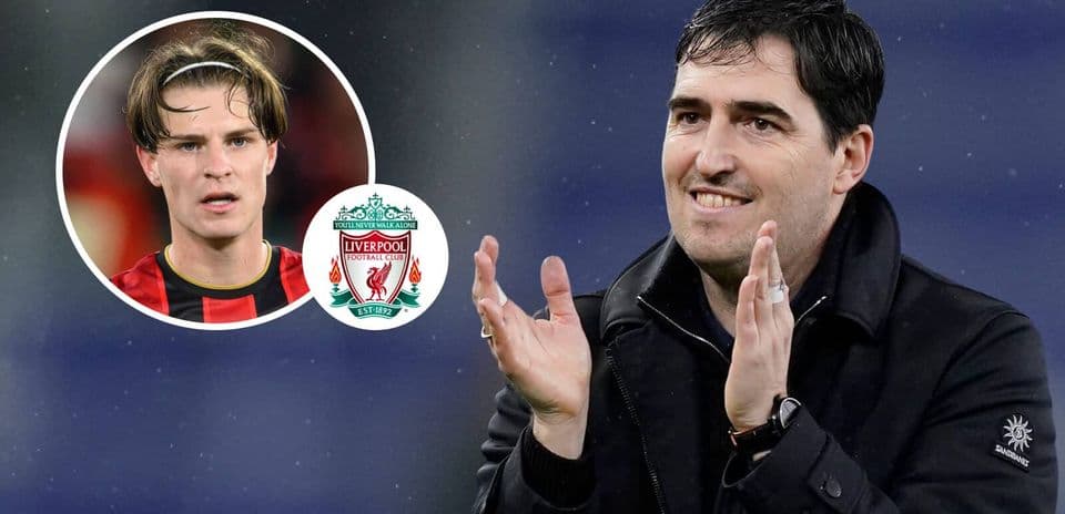Entrenador aplaudiendo con jugadores de Liverpool en fondo