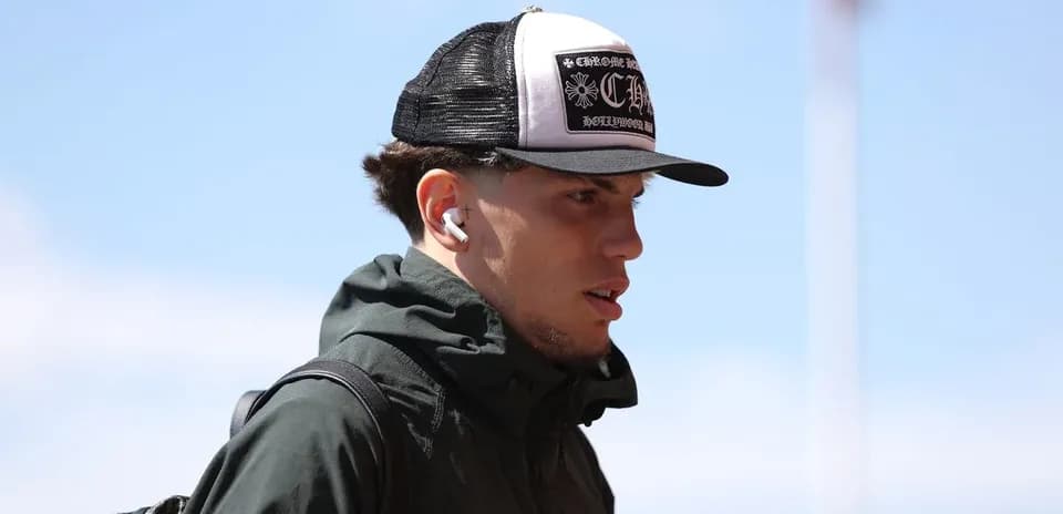 Jugador con gorra y auriculares llegando al estadio