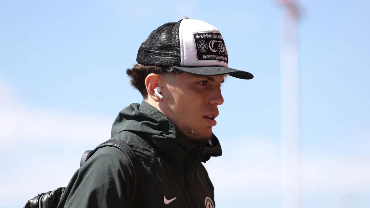 Jugador con gorra y auriculares llegando al estadio