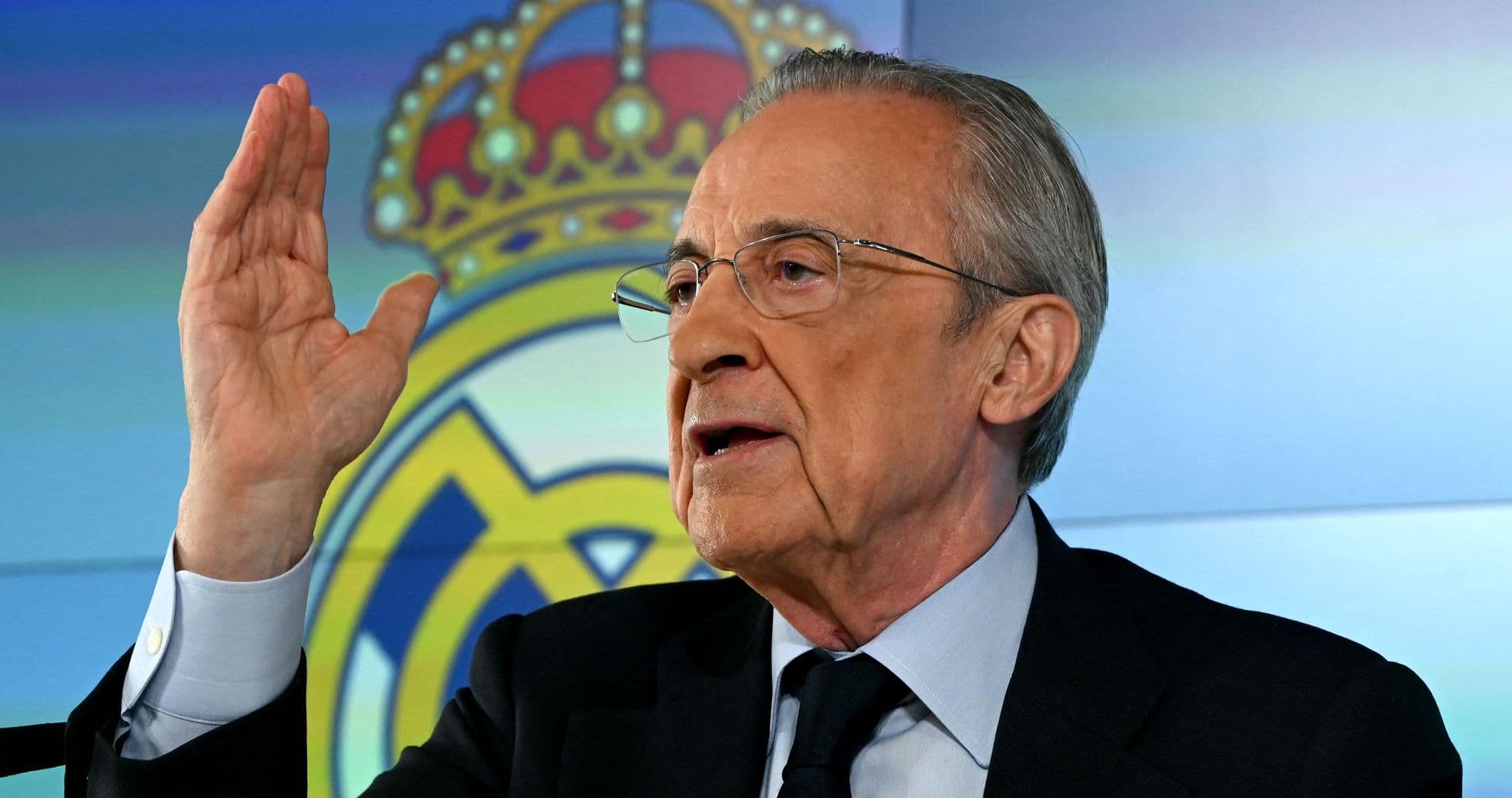 Presidente hablando en conferencia con logo del club