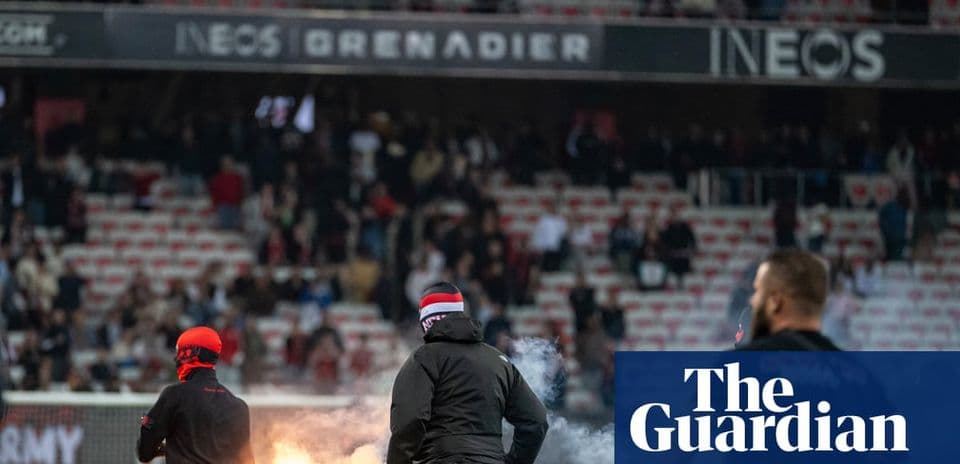 A group of fans with flares in stadium