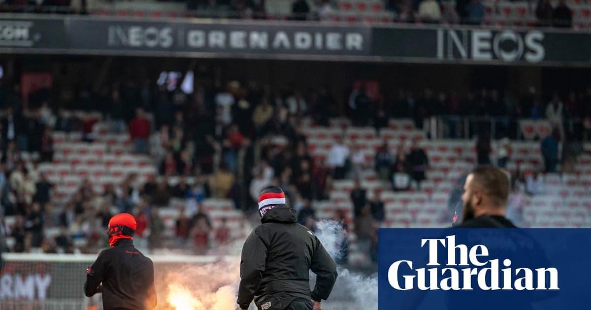 A group of fans with flares in stadium