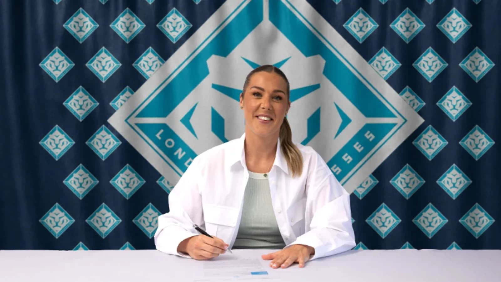 Jugadora firmando contrato frente a fondo de equipo