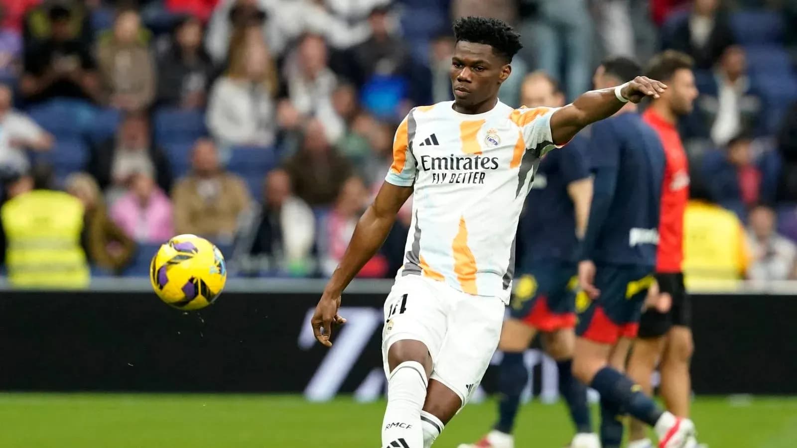 Jugador de Real Madrid lanzando el balón en el campo