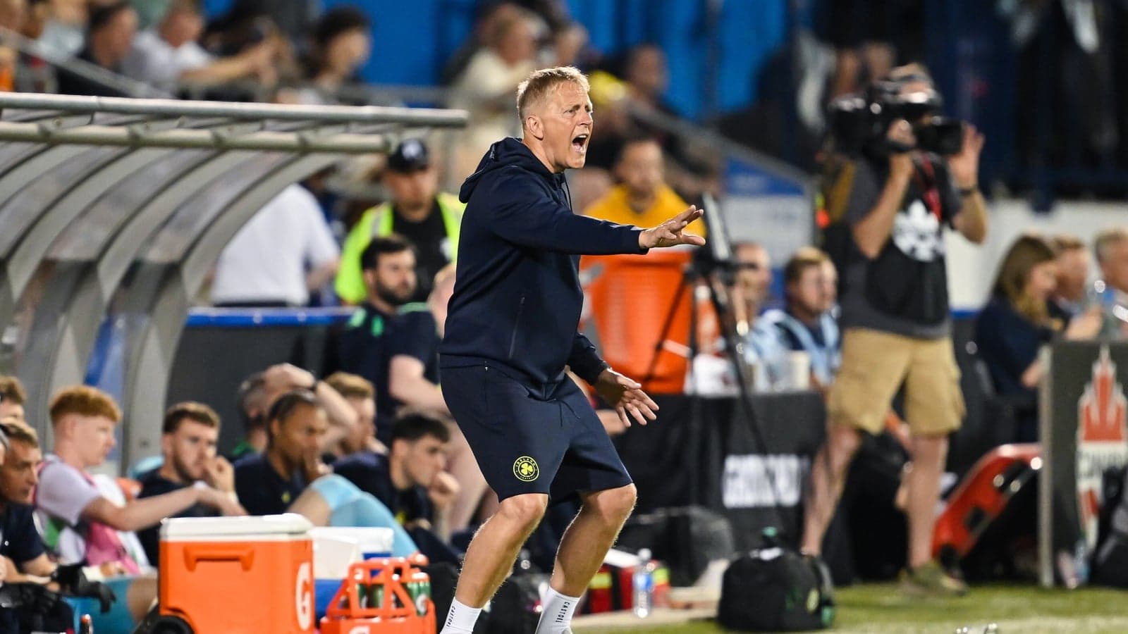 Entrenador dirigiendo desde la línea de banda