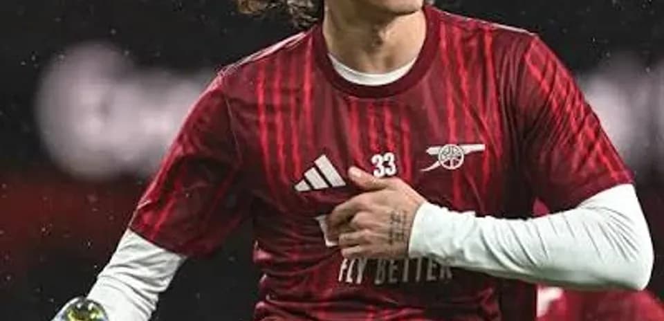 Jugador de Arsenal realizando estiramiento en el campo
